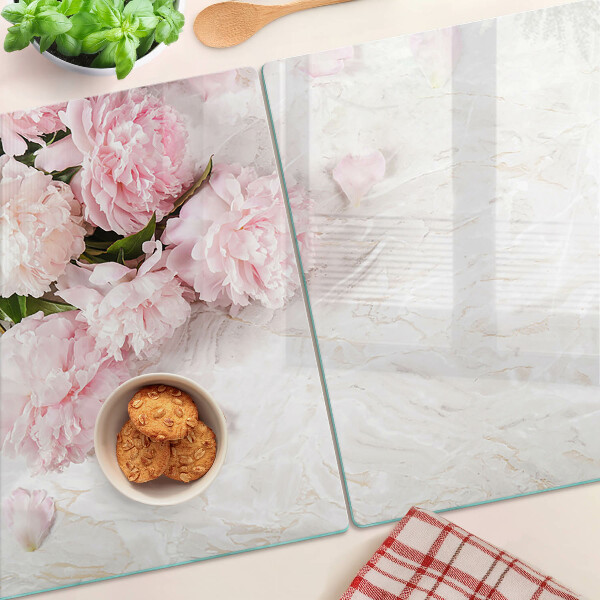 Glas-Schneidebrett mit Pfingstrosen auf marmoriertem Hintergrund