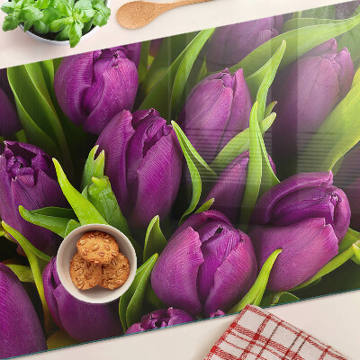 Schneidebrett mit lilafarbenen Tulpen und grünen Blättern