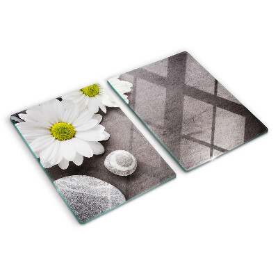 Schneidebrett Glas mit Blumen- und Steinemotiv im Hintergrund