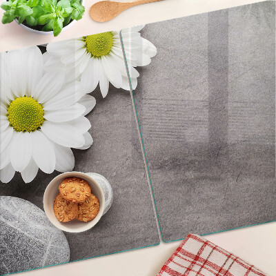 Schneidebrett Glas mit Blumen- und Steinemotiv im Hintergrund