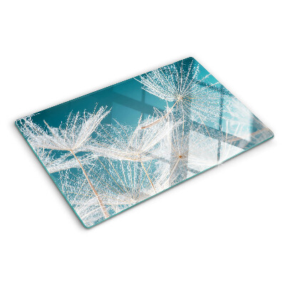 Glas-Schneidebrett mit Löwenzahn-Motiv auf blauem Hintergrund