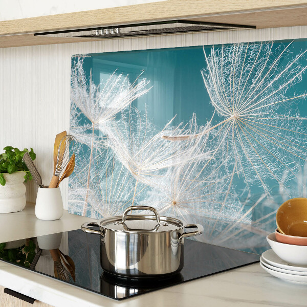 Glas-Schneidebrett mit Löwenzahn-Motiv auf blauem Hintergrund