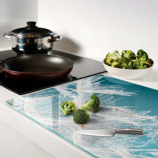 Glas schneidebrett Löwenzahn auf blauem Hintergrund