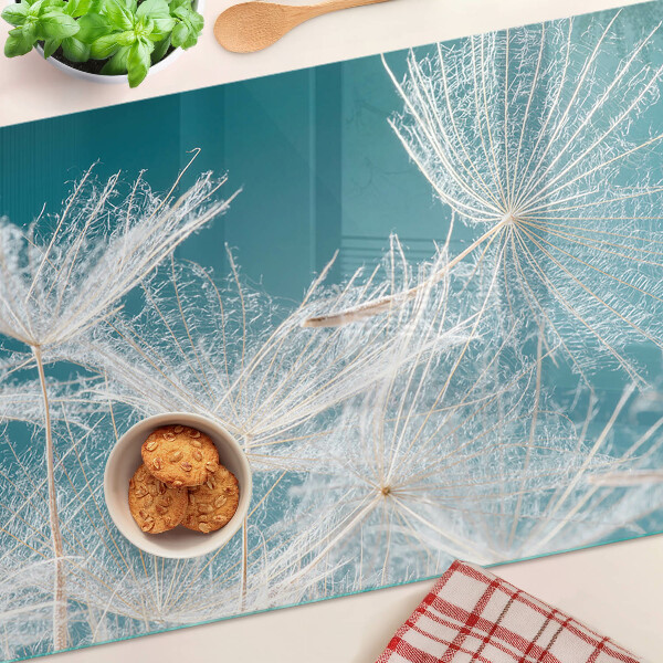 Glas schneidebrett Löwenzahn auf blauem Hintergrund