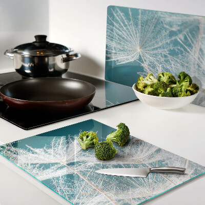 Glas-Schneidebrett mit Löwenzahn-Motiv auf blauem Hintergrund