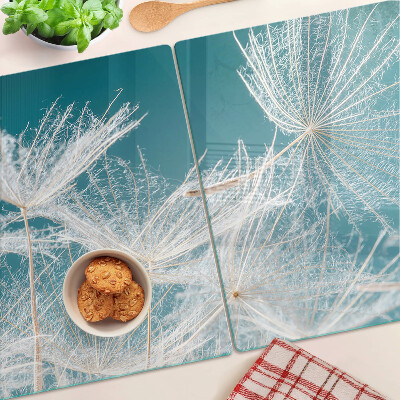Glas schneidebrett Löwenzahn auf blauem Hintergrund