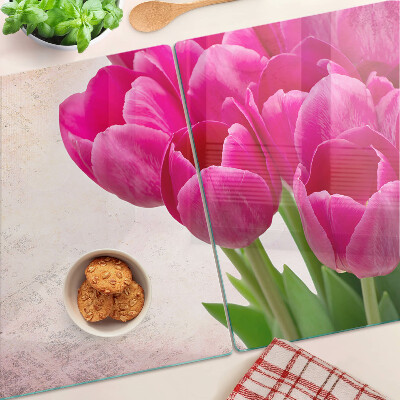 Schneidebrett glas Tulpenblüten auf rosa Hintergrund