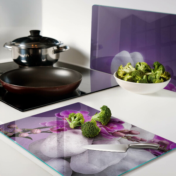 Schneidebrett Orchideenblüten vor einem steinernen Hintergrund