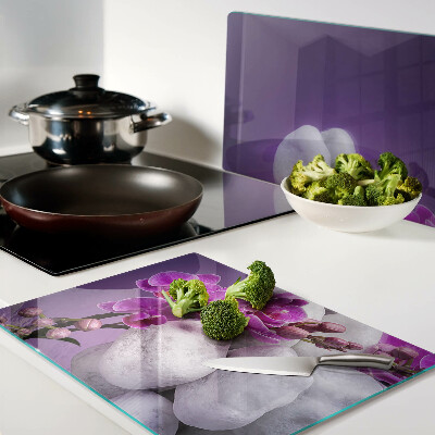 Schneidebrett Orchideenblüten vor einem steinernen Hintergrund