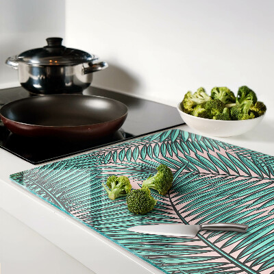 Glas Schneidebrett mit Palmenblättern auf rosa Hintergrund