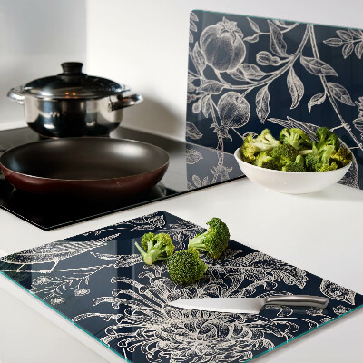 Schneidebrett mit Blumen- und Vogelmotiv auf dunklem Hintergrund