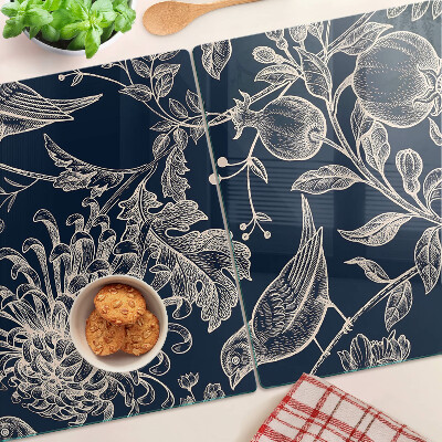 Schneidebrett mit Blumen- und Vogelmotiv auf dunklem Hintergrund