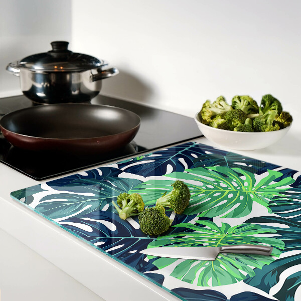 Schneidebrett glas Monstera-Blätter vor tropischem Hintergrund