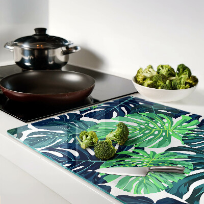 Schneidebrett glas Monstera-Blätter vor tropischem Hintergrund