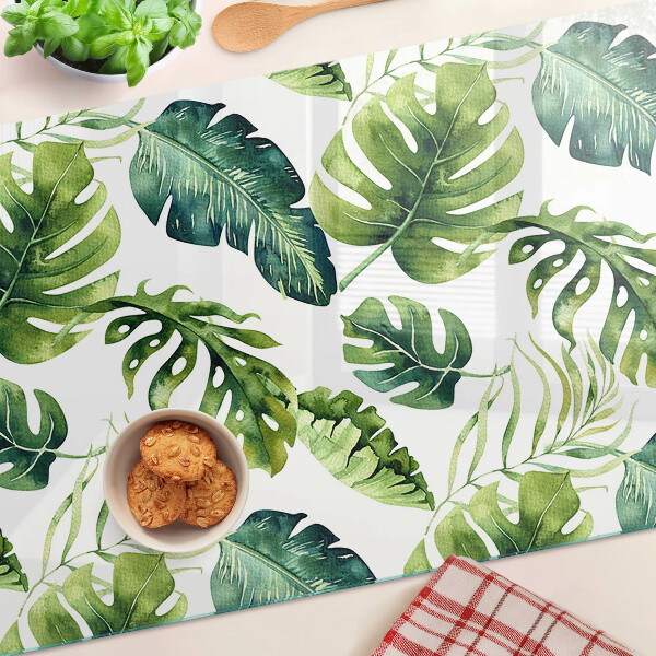 Schneidebrett mit Monstera‑Blättern in Grüntönen