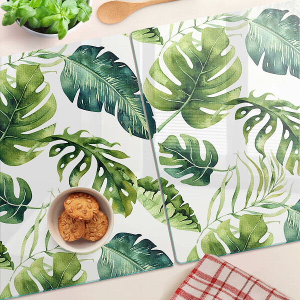Schneidebrett mit Monstera‑Blättern in Grüntönen