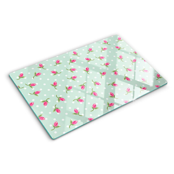 Glas-Schneidebrett mit rosa Tulpen auf grünem Hintergrund