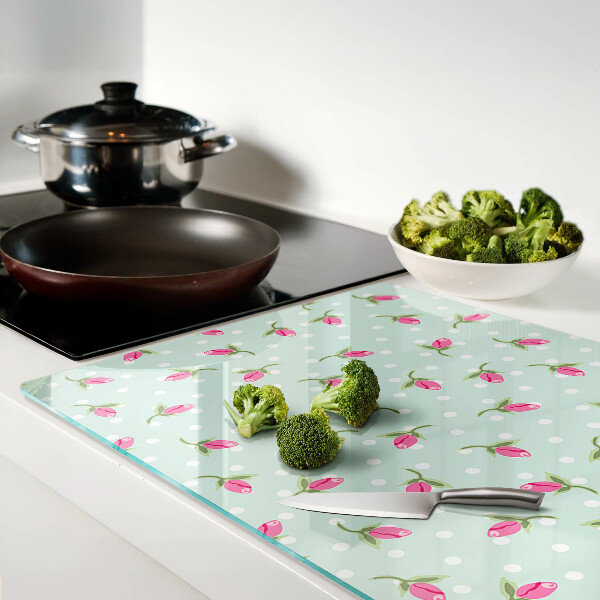 Glas-Schneidebrett mit rosa Tulpen auf grünem Hintergrund