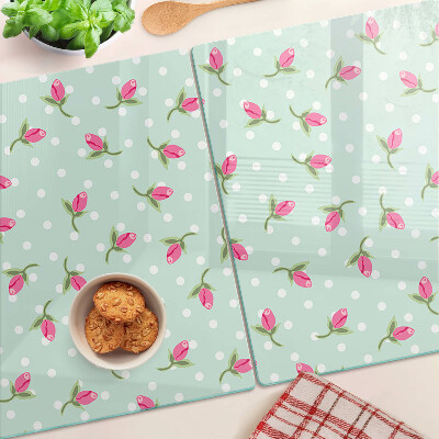 Glas-Schneidebrett mit rosa Tulpen auf grünem Hintergrund