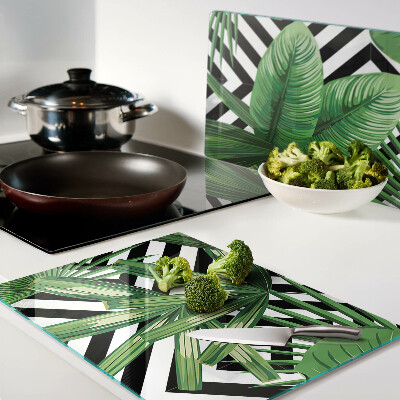 Schneidebrett mit Motiv tropischer Blätter auf gestreiftem Hintergrund