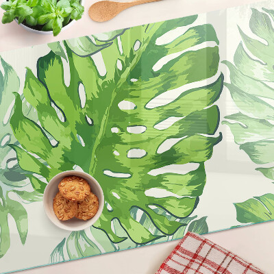 Schneidebrett mit Monstera-Blättern auf hellem Hintergrund