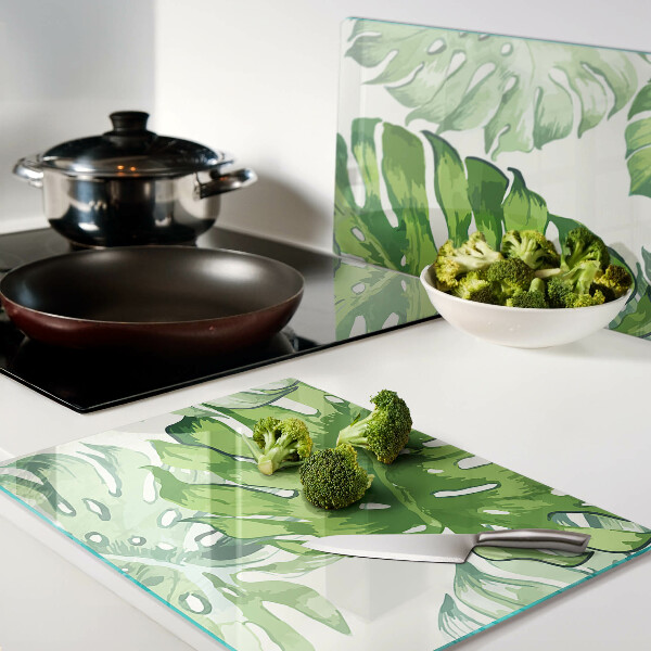 Schneidebrett mit Monstera-Blättern auf hellem Hintergrund