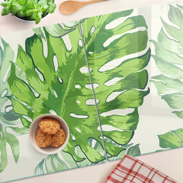 Schneidebrett mit Monstera-Blättern auf hellem Hintergrund