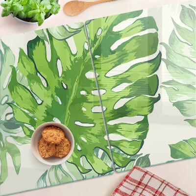 Schneidebrett mit Monstera-Blättern auf hellem Hintergrund