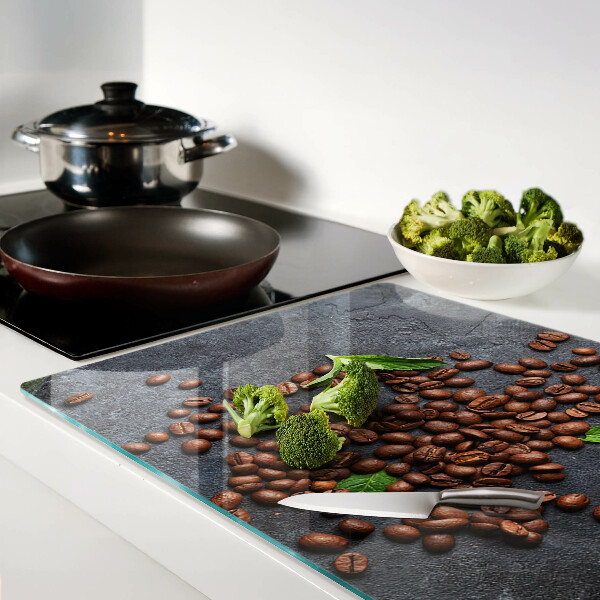 Glas schneidebrett Kaffeebohnen auf steinernem Hintergrund