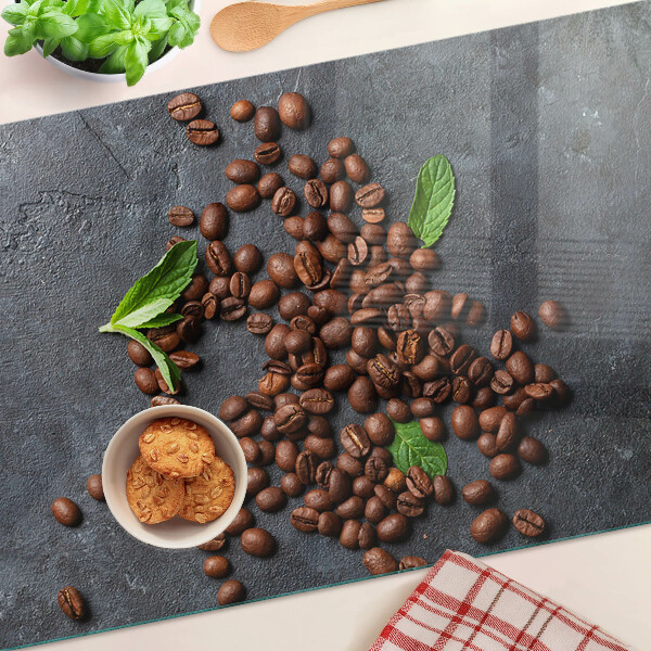 Glas-Schneidebrett mit Motiv aus Kaffeebohnen auf steinernem Hintergrund