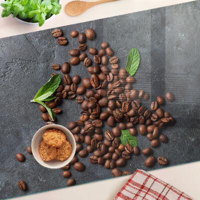Glas-Schneidebrett mit Motiv aus Kaffeebohnen auf steinernem Hintergrund