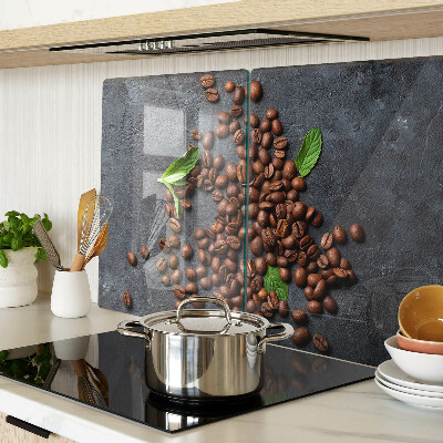 Glas-Schneidebrett mit Motiv aus Kaffeebohnen auf steinernem Hintergrund