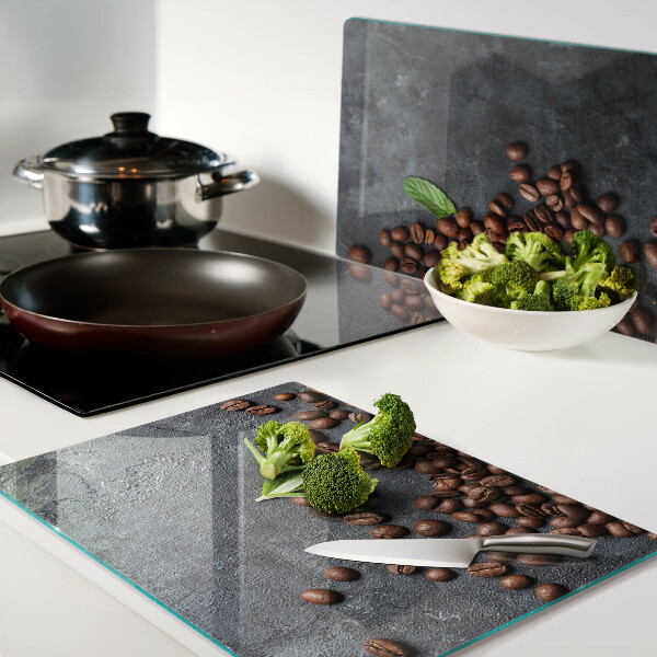 Glas schneidebrett Kaffeebohnen auf steinernem Hintergrund