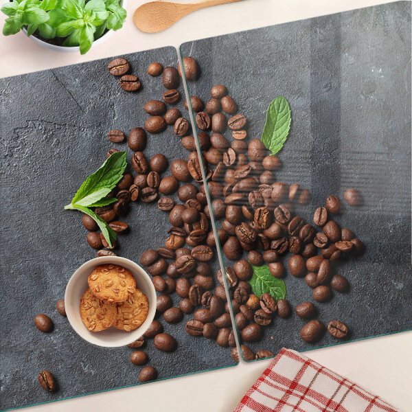 Glas-Schneidebrett mit Motiv aus Kaffeebohnen auf steinernem Hintergrund