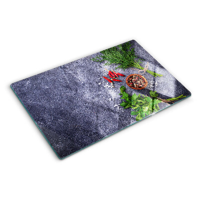 Schneidebrett Glas mit Motiv aus Kräutern und Gewürzen auf steinernem Hintergrund