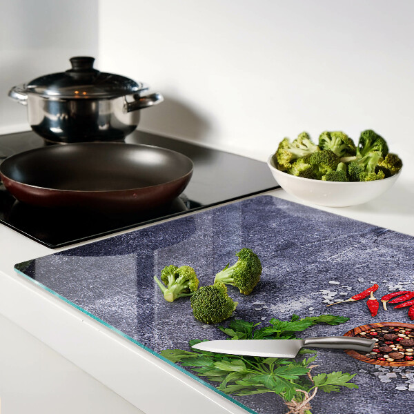 Schneidebrett Glas mit Motiv aus Kräutern und Gewürzen auf steinernem Hintergrund