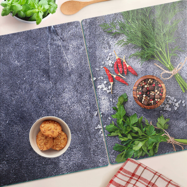 Schneidebrett Glas mit Motiv aus Kräutern und Gewürzen auf steinernem Hintergrund