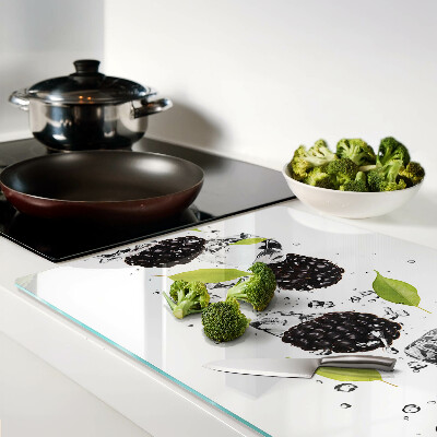 Glas schneidebrett mit Himbeeren, Blättern und Wassertropfen