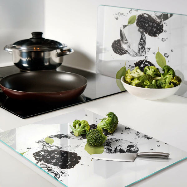 Glas schneidebrett Himbeeren mit Blättern und Wassertropfen