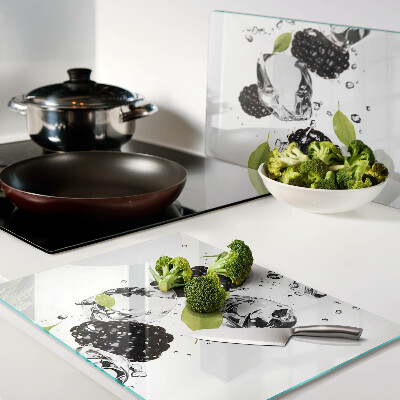 Glas schneidebrett Himbeeren mit Blättern und Wassertropfen