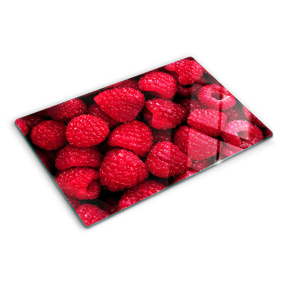 Schneidebrett Glas mit Himbeeren im Hintergrund