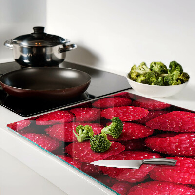 Schneidebrett Glas mit Himbeeren im Hintergrund