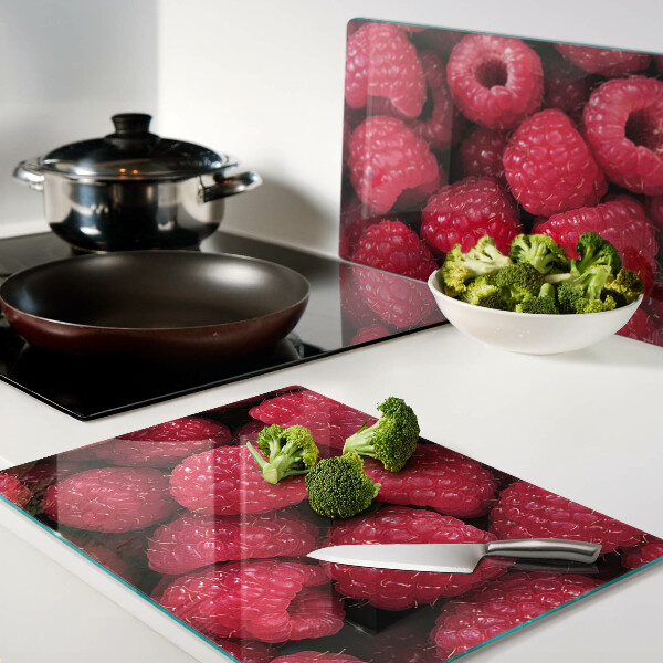 Schneidebrett glas Himbeeren im Hintergrund