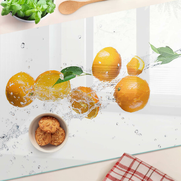 Glas schneidebrett Zitrusfrüchte mit Wasser
