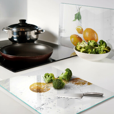 Glas schneidebrett Zitrusfrüchte mit Wasser