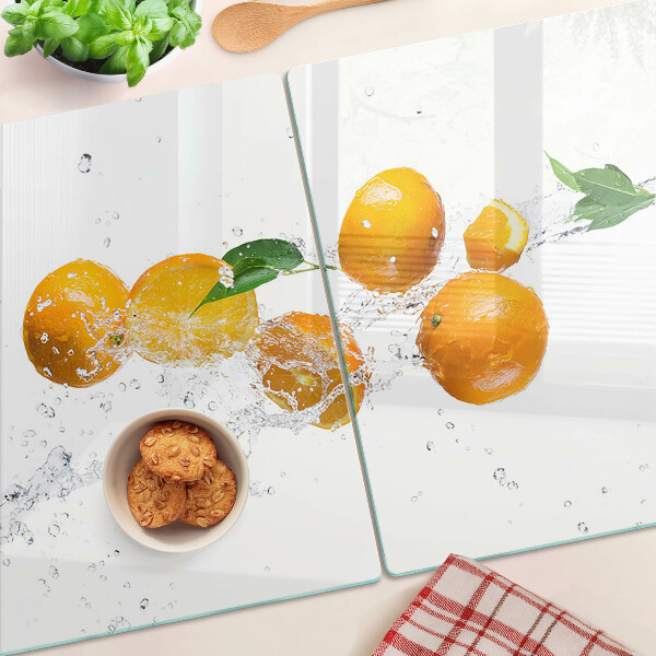 Glas schneidebrett Zitrusfrüchte mit Wasser