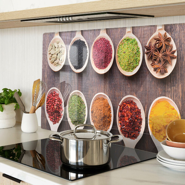 Schneidebrett Glas mit Gewürzen in Löffeln als Dekoration