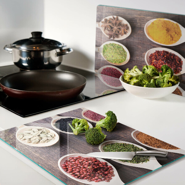 Schneidebrett Glas mit Gewürzen in Löffeln als Dekoration