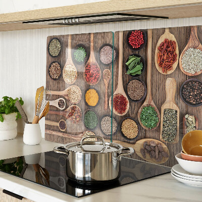 Glas-Schneidebrett mit Motiv aus Gewürzen und Kräutern in Holzlöffeln