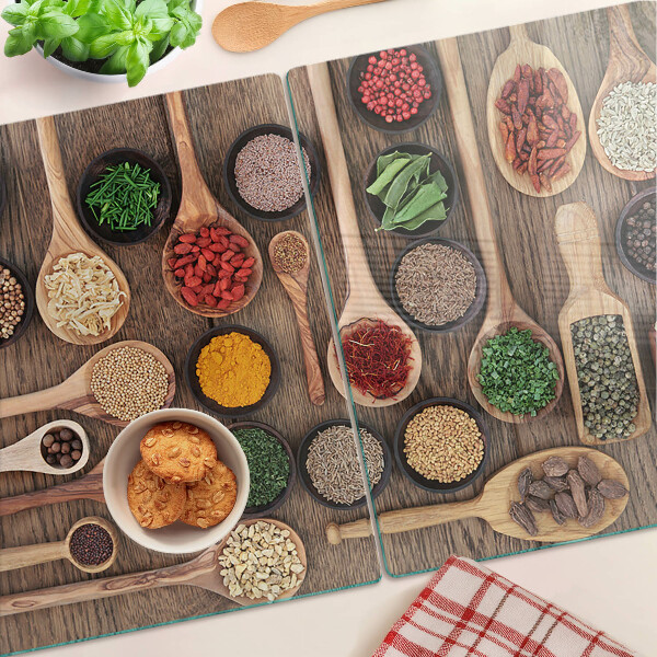 Glas schneidebrett Gewürze und Kräuter in Löffeln